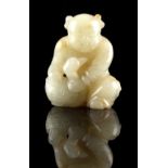A Chinese carved pale celadon jade figure of a seated boy holding a duck, 2.35ins. (6cms.) high (see
