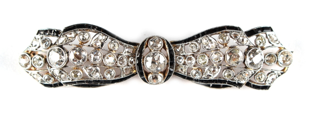 An Art Deco diamond & black onyx ribbon brooch, circa 1930, in yellow gold & platinum setting, 2.