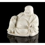 A Chinese blanc de Chine figure of Buddha or Budai, 18th century, modelled seated, 5.45ins. (13.