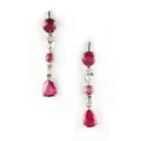 A pair of ruby & diamond pendant earrings, each with a pear cut ruby suspended below two round cut