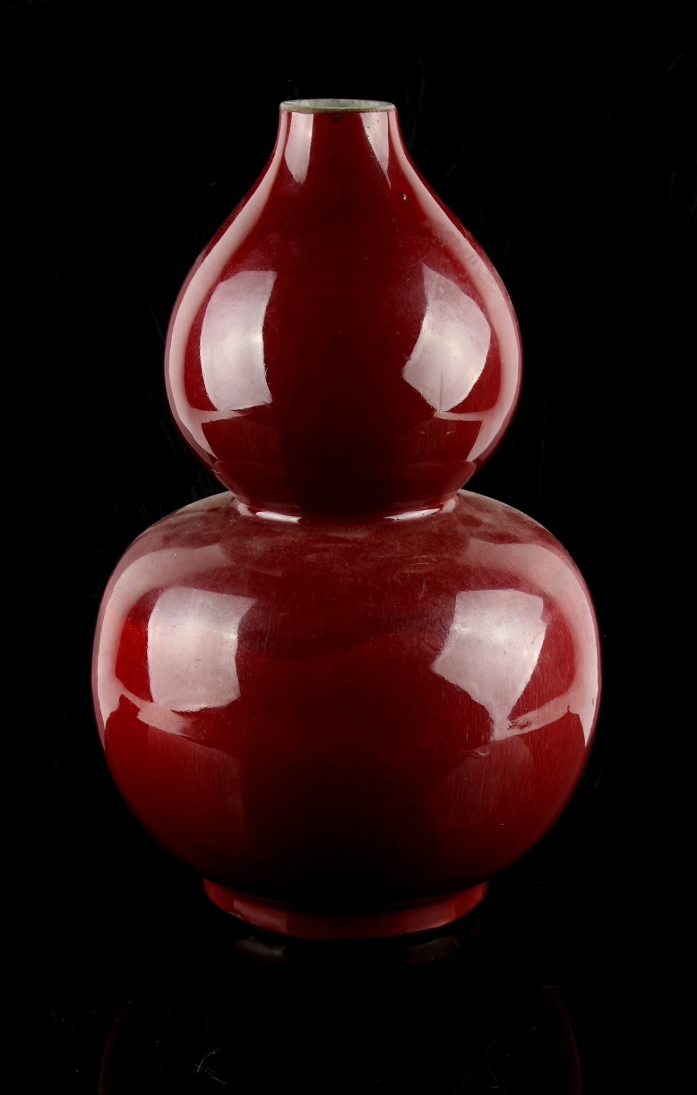 A Chinese copper red glazed double gourd vase, 18th / 19th century, slightly reduced in height &