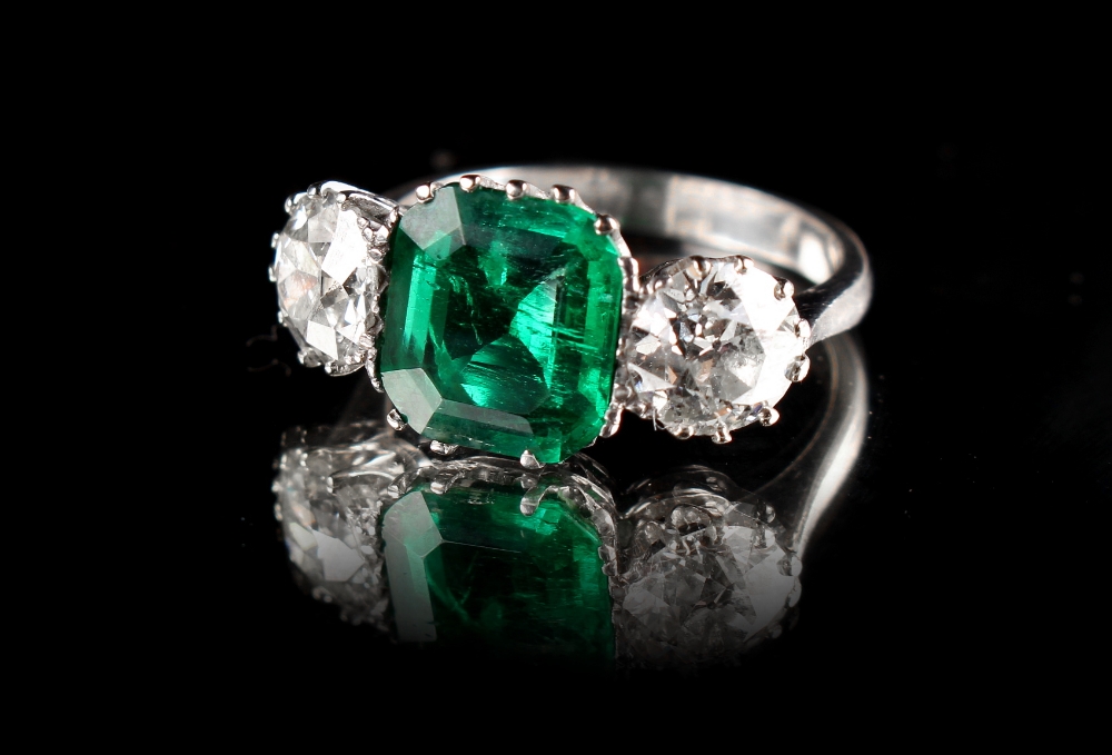 Property of a lady - an unmarked white gold or platinum synthetic emerald & diamond three stone