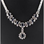 A 14ct white gold sapphire & diamond necklace, with stylised leaves & pendant flowerhead, the