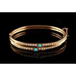 A late 19th / early 20th century unmarked yellow gold turquoise & seed pearl hinged bangle,