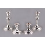 Property of a lady - two pairs of early 20th century silver candlesticks, the larger pair Birmingham