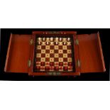 A private collection of chess sets - a folding travelling chess set in mahogany case with red