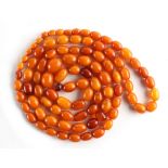 Property of a lady - a butterscotch amber bead necklace, the largest bead approximately 19mm long,