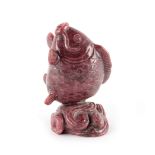 A carved pink hardstone, possibly rhodonite, model of a fish emerging from water, 3.45ins. (8.7cms.)