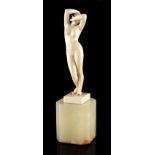 Property of a gentleman - an Art Deco carved ivory figure of a standing female nude, on green onyx