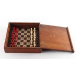 A private collection of chess sets - a travelling chess set with red stained & natural pieces, in