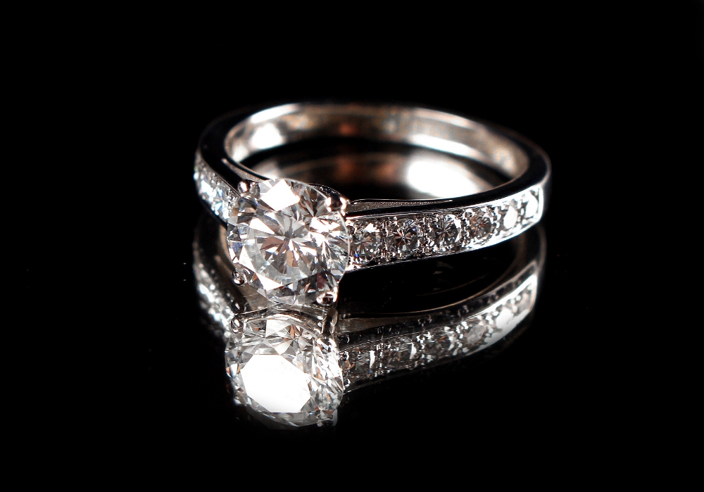 A platinum or white gold certificated diamond solitaire ring, the round brilliant cut diamond