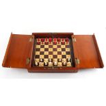 A private collection of chess sets - a folding travelling chess set in mahogany case with red