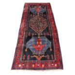 A Kordi woollen hand-made runner with navy ground, 140 by 59ins. (355 by 150cms.) (see