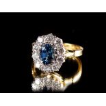 An 18ct yellow gold sapphire & diamond oval cluster ring, the oval cut sapphire weighing