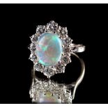 An unmarked white gold opal & diamond oval cluster ring, the oval opal weighing approximately 2.28