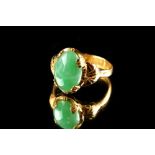 A Chinese high carat yellow gold certificated untreated jadeite ring, the oval cabochon cut stone of