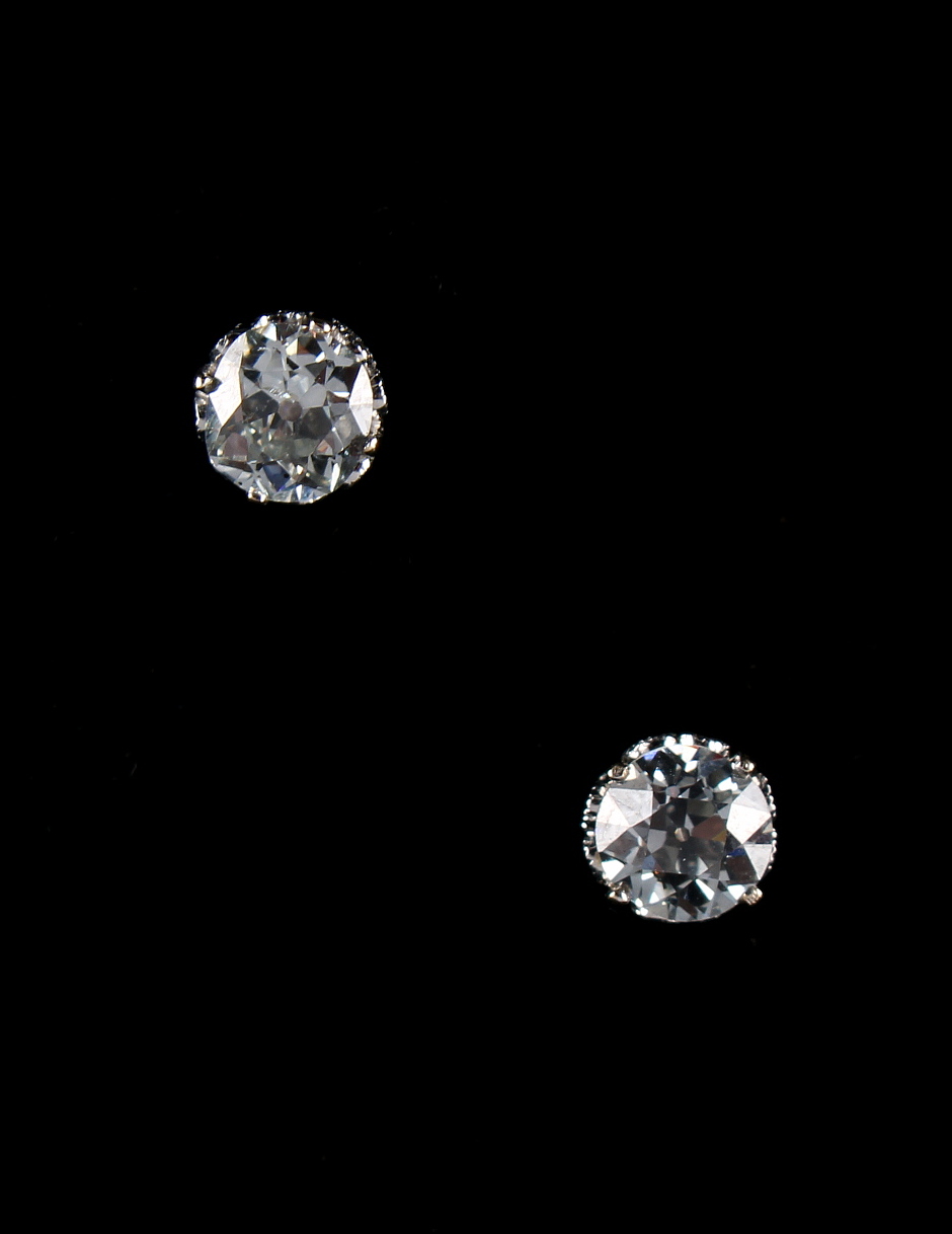 A pair of faint blue diamond stud earrings, each round brilliant cut diamond in diamond set