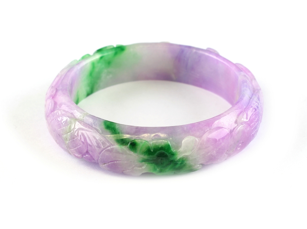 A Chinese lavender & apple green hardstone bangle, carved in relief with fish, 2.5ins. (6.3cms.)