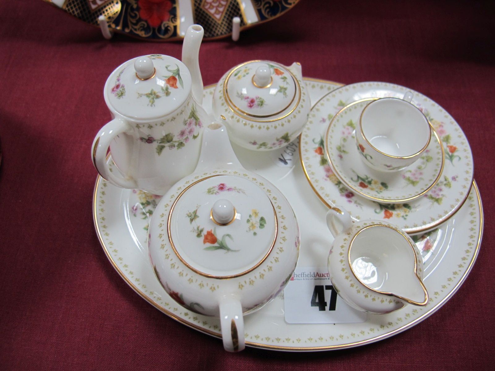A Wedgwood Bone China Miniature Four Piece Tea Set, matching trio and oval tray. (8)
