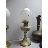 An Early XX Century Oil Lamp, in brass and floral pottery on weighted iron base.