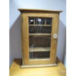 A XIX Century Pine Wall Cabinet, with glass handle to glazed door, pigeon hole interior.