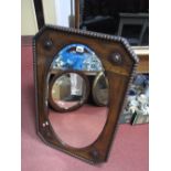 A 1920's Oval Bevelled Wall Mirror, in rectangular oak frame with canted corners.