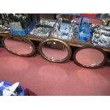 Three Oval Bevelled Wall Mirrors, in mahogany effect frames, circa 1900.