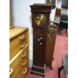 An Oak Grandmother Clock, with a caddy top, brass dial, shaped door, on a plinth base.