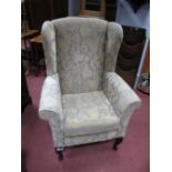 A Wing Back Easy Armchair, floral upholstered on cabriole legs.