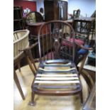 An Ercol Low Open Armchair, spindle back with fleur de lys pierced splat, 'H' stretchered legs, (