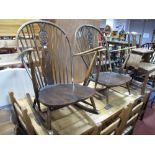 An Ercol Dark Elm Spindle Back Rocking Chair, fleur de lys splat, open arms, shaped seat and a