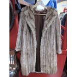 A Ladies Light Brown Knee Length Fur Coat.