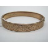 A Bangle, leaf engraved to the front, hinged to snap clasp, inscribed "From Lila in Memory of