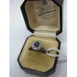 A Sapphire and Diamond Cluster Ring, oval claw set to the centre, within border of brilliant cut