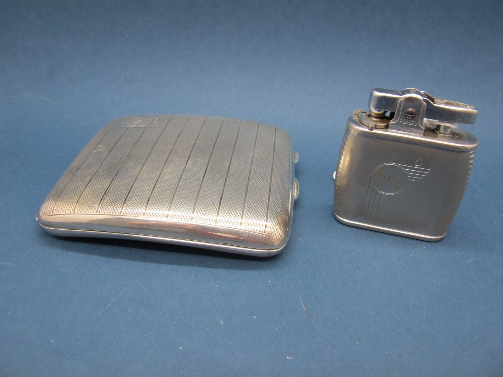 A Hallmarked Silver Cigarette Case, allover engine turned, initialled; together with a Ronson Viking