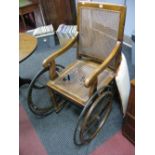 An Edwardian Open Arm Bath Chair, with rattan back and seat (damages).