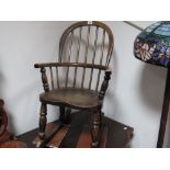 A XIX Century Ash and Elm Child's Rocking Chair, with a hooped back, rail supports, on turned legs