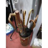 Walking Sticks, gentleman's umbrellas, in a brass stick stand.