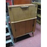 A Teak Bureau, with fall front over sliding doors on splayed legs.