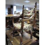 An Early XX Century Continental Walnut 'X' Framed Chair, with carved head finials to upholstered