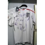 England Autographs - unverified. Fifteen Signatures In black Marker, on a white Umbro Home shirt.