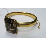 A Single Stone Set Bangle, large rectangular four claw set to the front, high on plain bangle,