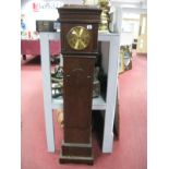 An Oak Grandmother Clock, with a caddy top, brass dial, shaped door, on a plinth base.