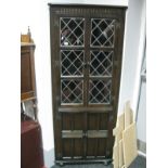 An Oak Corner Freestanding Display Cabinet, having upper lead glazed doors.