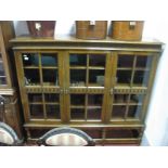 An Oak Display Cabinet Circa 1920's, with knulled carving to top rail and three glazed doors,