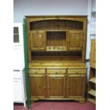 A Modern Pine Dresser, the top with open shelves and cupboard doors over a frieze of three small