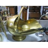 A XIX Century Brass Helmet Shaped Coal Scuttle, with a hooped handle on a circular base; together