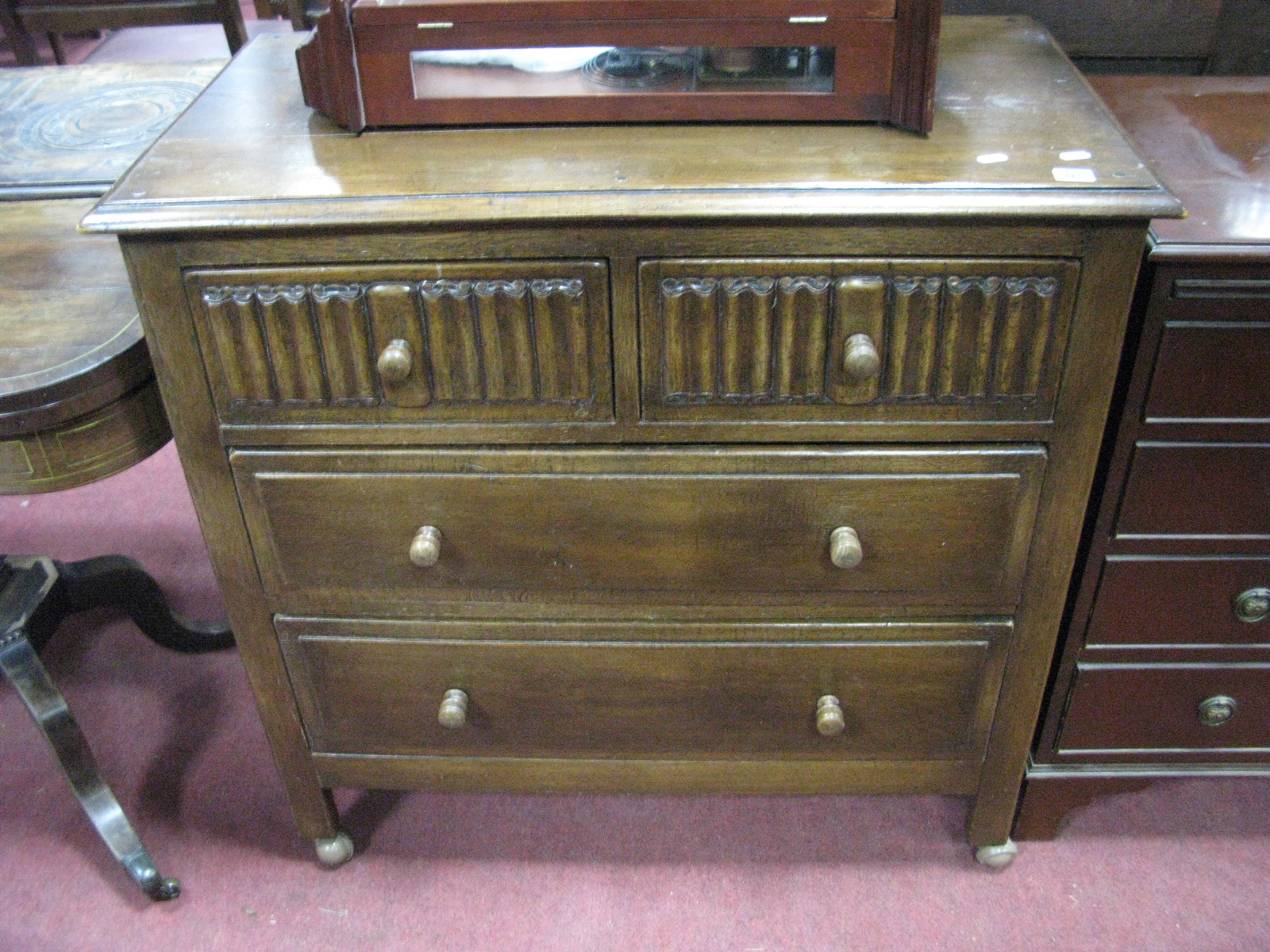 A 1920's Oak Chest of Drawers, moulded edge over two short drawers with linen fold decoration, above