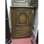 An Oak Cabinet, with carved and arched panel cupboard door over twin drawers, 76cm wide.