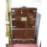 A Mahogany Drinks Cabinet, with fleur de lys cresting, carved apron, on cabriole legs.